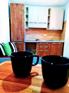 dos tazas negras sentadas en una mesa de madera en Apartment 1913 en Ponticelli