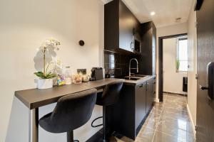 a kitchen with a counter with two chairs at a table at Black Pearl Suite Luxe Centre-Ville Amiens à 200m de la Cathédrale in Amiens