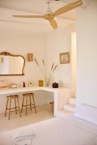 um quarto branco com uma ventoinha de tecto e uma secretária em La Pandilla Ibiza em Sant Francesc de s'Estany