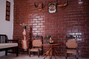 a brick wall with a table and chairs in a room at Taura Comfort in Bangalore