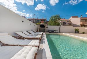 een zwembad met ligstoelen naast een huis bij Apartment Jakov with pool in Zadar