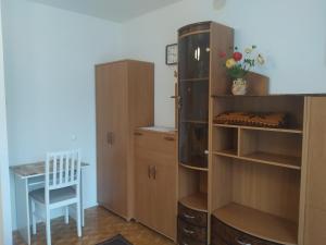 Pokój z drewnianymi szafkami, stołem i krzesłem w obiekcie Apartament w Centrum Chełma w mieście Chełm