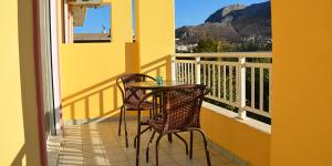 a table and chairs on a balcony with a view at Pantheon Deluxe Apartments in Archangelos