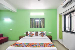 een slaapkamer met een groot bed met groene muren bij Shrikrishna Studio Goa in Goa Velha