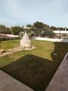 a yard with a stone structure in the grass at Villa Anna Maria in Polignano a Mare