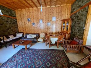 ein Wohnzimmer mit einem Sofa und einem Tisch in der Unterkunft Elpiniki's Old House in Kalopanagiotis