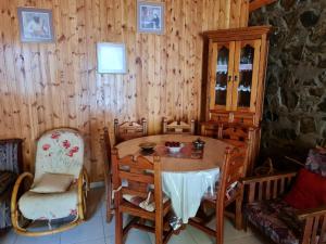 a dining room with a wooden table and chairs at Elpiniki's Old House in Kalopanayiotis