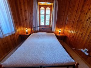 1 dormitorio con 1 cama con 2 luces en 2 mesas en Elpiniki's Old House, en Kalopanayiotis