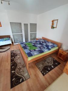 ein Schlafzimmer mit einem Bett und zwei Teppichen in der Unterkunft Agro privat in Hrabušice