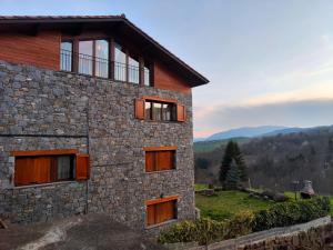 uma casa de pedra com vista para as montanhas em Allotjaments Paratge Fabas em Molló