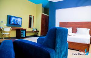 een slaapkamer met een bed en een stoel en een tv bij Cate Hotel Morogoro in Morogoro