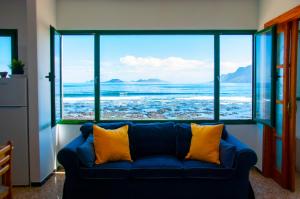 a blue couch in a room with a view of the ocean at Arena y el Mar in Famara