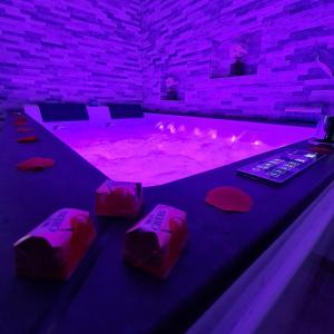 - un bain à remous dans une pièce avec éclairage violet dans l'établissement Superbe appartement privé avec jacuzzi, à Saint Etienne