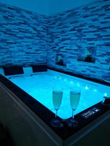 Superbe appartement privé avec jacuzzi في Saint Etienne: حمام سباحة مع كأسين من النبيذ على طاولة