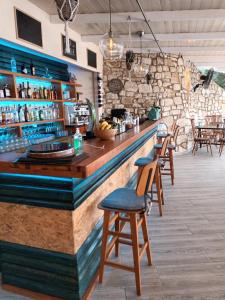 a bar in a restaurant with wooden stools at Agnanti in Parga