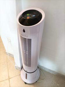 a white heater sitting on the floor next to a wall at Sardinia Yellow House in Solanas