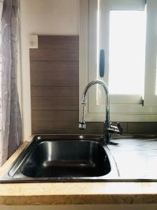 um lavatório de aço inoxidável numa cozinha com uma janela em Terrazza su Scicli em Scicli