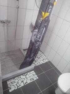 una doccia in bagno con palo nero di Guesthouse Panorama a Mostar