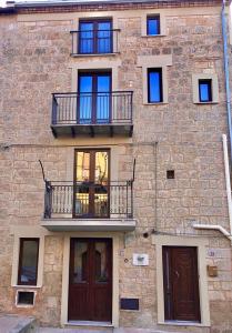 een bakstenen gebouw met twee balkons en twee deuren bij LA CASA DEL BORGO in Petralia Soprana