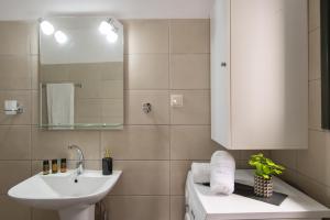 a white bathroom with a sink and a mirror at Square Apartment in Kambanós