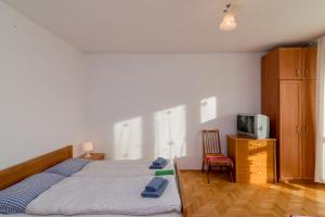 a bedroom with a bed and a tv and a chair at Rooms in the center in Gdańsk