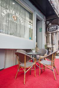 three chairs and a table on a red carpet at Armar Hotel in Istanbul