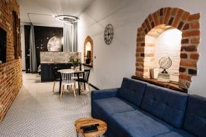 a living room with a blue couch and a table at Apartamenty K2 Podmurna 36 in Toruń