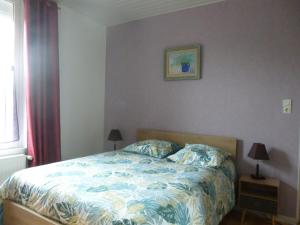 a bedroom with a bed and a picture on the wall at maison du haut pont in Saint-Omer