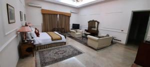 um quarto de hotel com uma cama, um sofá e cadeiras em Etihad Club by Faletti's Hotel em Rahimyar Khan