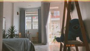 een woonkamer met een bed en een raam bij Rot Homestay in Da Lat