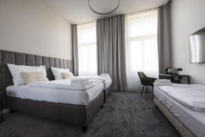 a hotel room with two beds and a chair at The Gold Bank in Prague