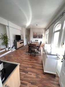 a kitchen and living room with a wooden floor at Ganze Citywohnung 4 Schlafzimmer in Hannover