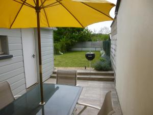 a table with a yellow umbrella on a patio at maison du haut pont in Saint-Omer