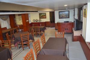 a dining room with tables and chairs and a television at HOTEL RATHNA RESIDENCY in Madurai