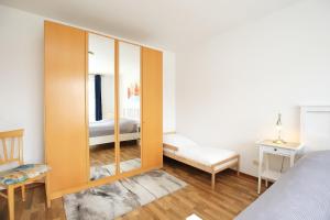 a bedroom with a bed and a large wooden cabinet at Dünenblick Wohnung 48 in Boltenhagen