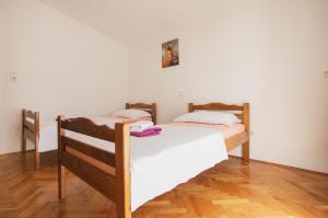 two twin beds in a room with wooden floors at Plava Adria Podstrana in Podstrana