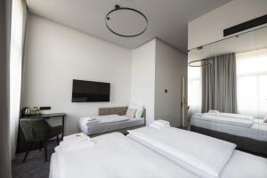 a hotel room with two beds and a tv at The Gold Bank in Prague