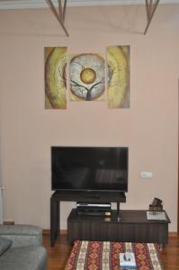 a living room with a flat screen tv and three pictures at Yerevan-Sky with terrace in Yerevan