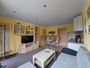 a living room with a couch and a table and a kitchen at Ferienwohnung Robby in Fulgen