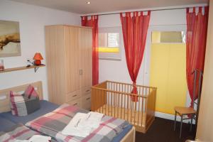 a bedroom with a crib and red curtains at Ferienwohnung Robby in Fulgen