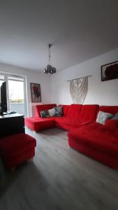 a living room with red furniture and a red couch at Apartament Widok z tarasami in Ostróda
