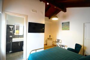 a bedroom with a bed and a bathroom with a television at La Casa di Nenna in Trentinara