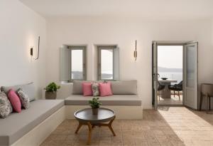 - un salon avec un canapé et une table dans l'établissement Asha Luxury Suites, à Fira