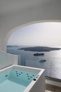 eine Badewanne mit Meerblick in der Unterkunft Asha Luxury Suites in Fira
