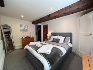 a bedroom with a large bed and a wooden ceiling at The Mill in Hinton on the Green