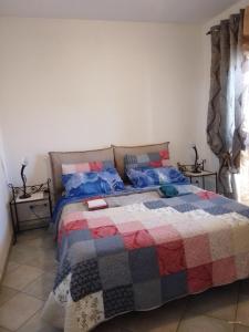 una camera con un letto con una trapunta sopra di Vivere in famiglia a Orosei