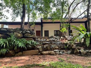 a stone retaining wall in front of a house at Nugasewana Guest in Anuradhapura