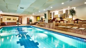 una gran piscina con azulejos azules en una habitación de hotel en Hotel Skalny, en Zakopane