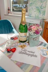 eine Flasche Champagner und Blumen auf dem Tisch in der Unterkunft Haus Haeger in Dahme