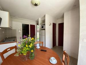 a dining room table with a vase of flowers on it at Les gîtes de Beille in Les Cabannes